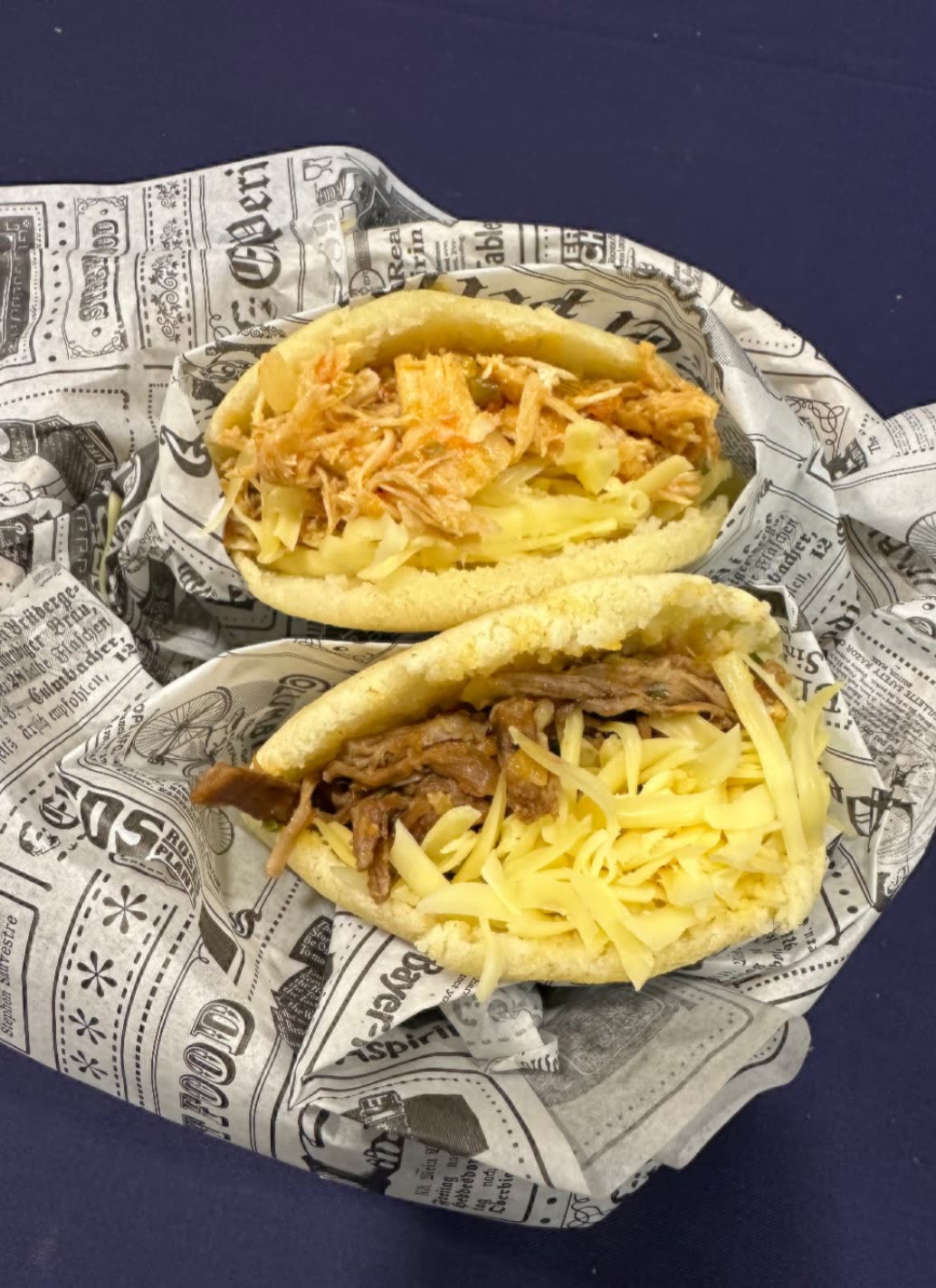 Dos arepas rellenas de pollo esmechado y de carne mechada con queso